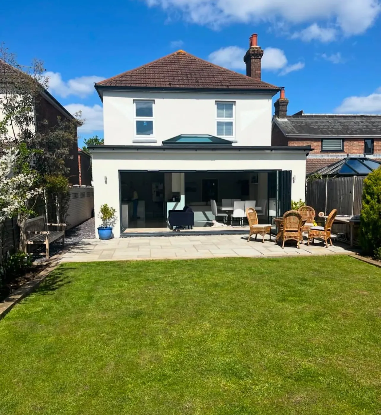A large white house with a patio and lawn.
